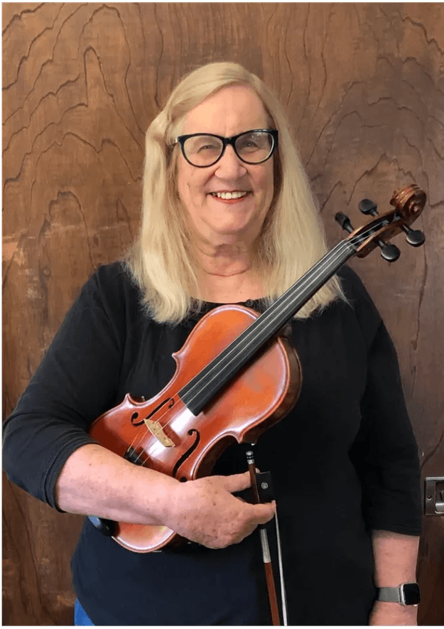 Dr. Colleen Snyder holding a violin and bow.